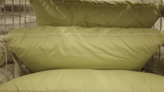 New soft fluffy pillows arranged in stack on a store shelf, home closet or laundry room. Comfortable modern pillows for a household.