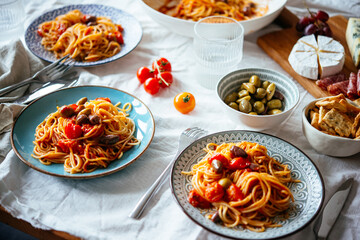 Friends having a pasta dinner with wine at home.