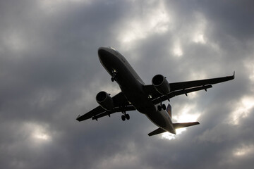 Airplane flying through dramatic cloudy sky, showcasing powerful engines and sleek design, symbolizing travel, adventure, and modern aviation technology