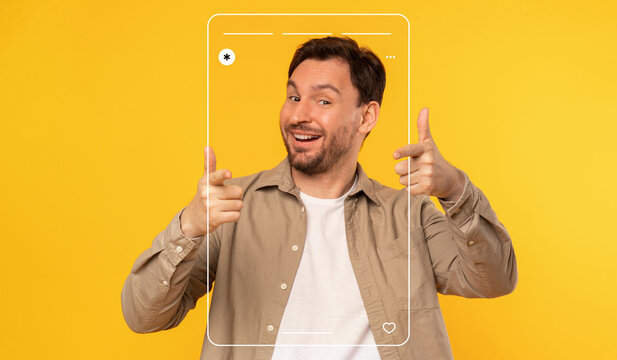A cheerful man is posing playfully with a frame that resembles a phone screen. He smiles and gives thumbs up against a vibrant yellow backdrop, creating a fun and lively atmosphere.