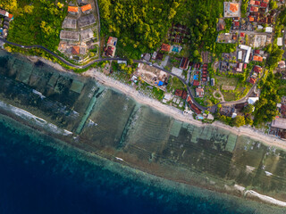 Tropical island coastline in Indonesia showing lush forest and villages at sunset
