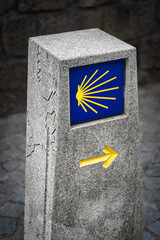 Iconic pilgrimage waymarker guides the way on the Camino de Santiago with a scallop shell symbol. A concept for journey, faith, and direction.