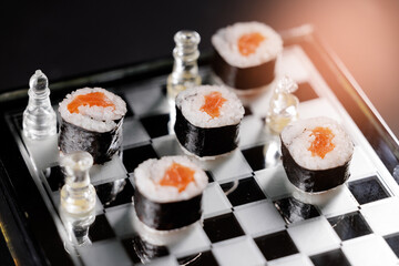 Fashion food concept photography Sushi rolls arranged on glass chessboard with clear chess pieces in artistic display