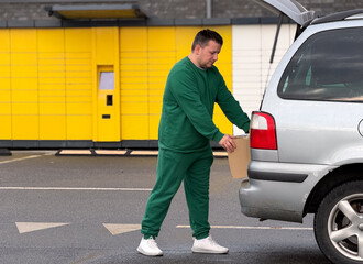 Man loading package into car in parking area