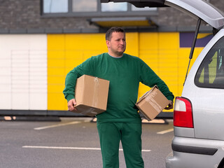 Man carrying boxes near vehicle