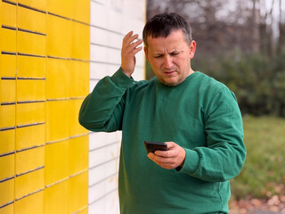 Man looking confused while using smartphone