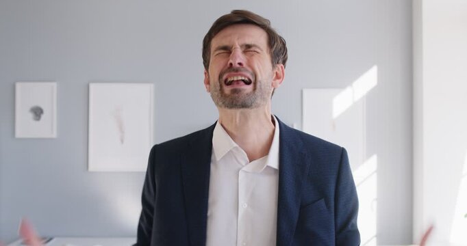 Young stressed businessman in a suit crying and screaming. Man feeling very sad, angry and desperate because of his problems at work, failure and business bankruptcy. Emotions concept