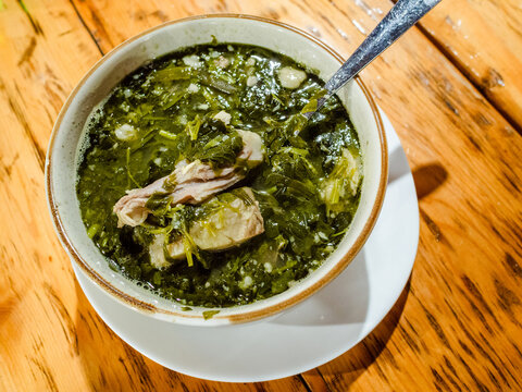 Georgian Chakapuli soup in bowl on wooden table