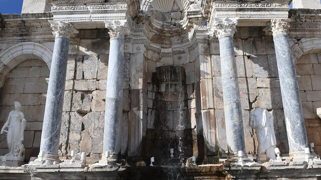 The restored facade and flowing water of the Antonine Nymphaeum in the ancient city of Sagalassos. Detailed close-up of the historic Roman structure.