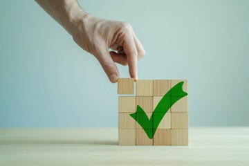 Hand building a green check mark with wooden cubes, success sign