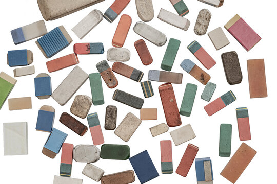 A collection of various used and worn-out erasers, flat lay photograph of a scattered collection of vintage, heavily used, and well-worn rectangular erasers