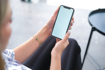 Woman's hand texting on mobile phone in coffee shop.