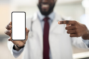 Modern smartphone with white blank screen in unrecognizable black doctor hand, man in white robe pointing at gadget, mockup, cropped. Mobile application for remote healthcare