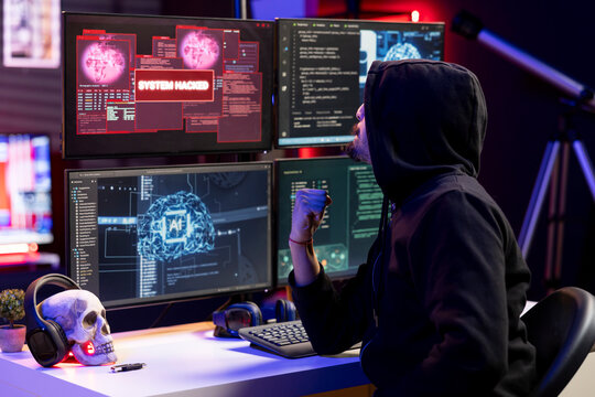 Hacker pumps fist, satisfied after launching phishing attacks tricking users into revealing credit card data. Jolly rogue software developer excited after DDoS attacks flood servers and crash websites