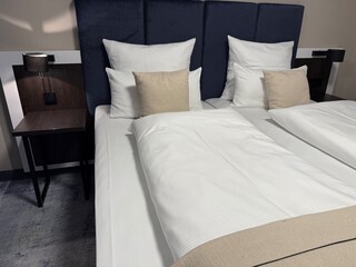 Modern hotel bedroom interior with neatly made double bed and elegant soft lighting