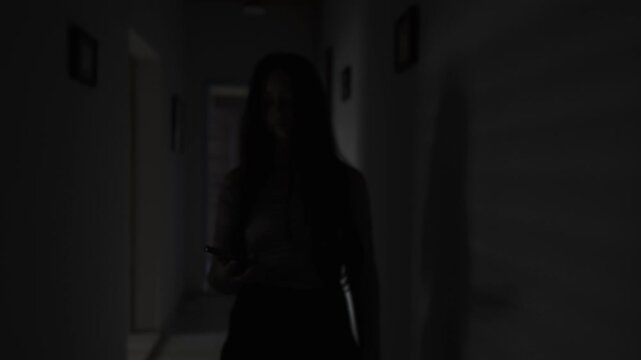 Woman secretly answering phone call in dark hallway, whispering and hiding from boyfriend, relationship betrayal