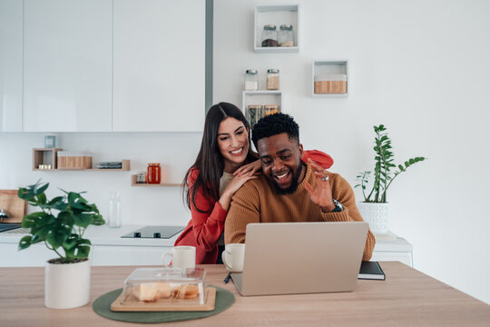 Happy interracial couple enjoying video call at home