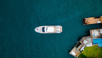 Fototapeta premium Luxury Boat Speedboat Yacht Tropical Paradise Beach Blue Sea Atlantic Ocean Coast Atlantic Forest Angra Dos Reis Rio De Janeiro Brazil South America Idyllic Heavenly Summer Colorful Saturated Green