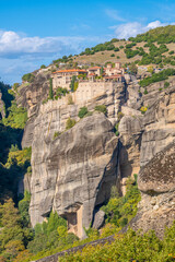 The Holy Monastery of Varlaam Perched on a Steep Sandstone Rock Formation in Meteora, Greece, under a Bright Blue Sky