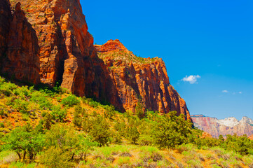 Zion National Park, located in Utah state, includes mountains, canyons, buttes, mesas, monoliths, rivers, slot canyons, and natural arches.