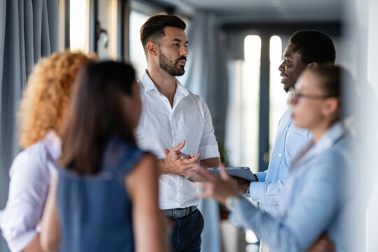 Business professionals networking and discussing ideas in modern office hallway