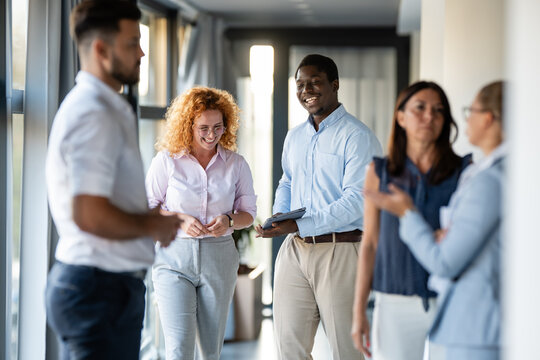 Successful diverse business team communicating in office hallway - Powered by Adobe