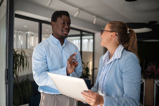 Business colleagues discussing project details in office setting