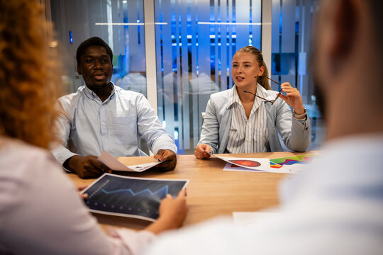 Diverse business team collaborating on financial meeting in modern office