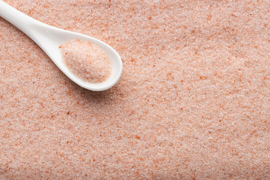 Fine Himalayan pink salt spilled from a spoon