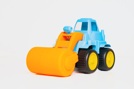 Bright blue toy roller truck with an orange drum sits on a white surface, inviting kids to engage in construction-themed imaginative play and creativity.