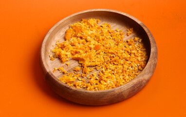 orange zest in a bowl on an orange background