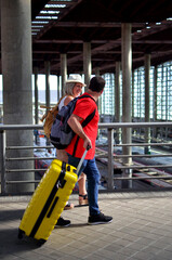 Couple walking with luggage in busy train station