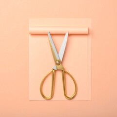 Golden scissors on peach paper with rolled top edge