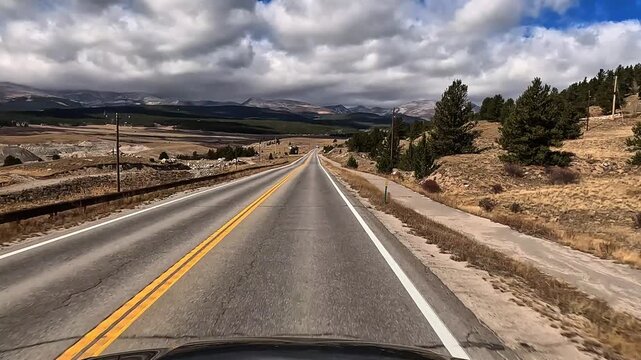 Drive along Colorado Highway 9 north in late fall early winter through rural high elevation area with snowy mountains in the distance