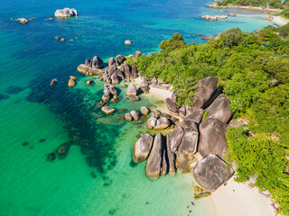 Stunning aerial view of Tanjung Tinggi Beach in Belitung, Indonesia. Known as 'Laskar Pelangi Beach', this popular destination features giant granite boulders and clear turquoise water.