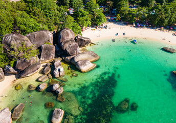 Stunning aerial view of Tanjung Tinggi Beach in Belitung, Indonesia. Known as 'Laskar Pelangi Beach', this popular destination features giant granite boulders and clear turquoise water.