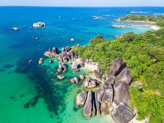 Stunning aerial view of Tanjung Tinggi Beach in Belitung, Indonesia. Known as 'Laskar Pelangi Beach', this popular destination features giant granite boulders and clear turquoise water.
