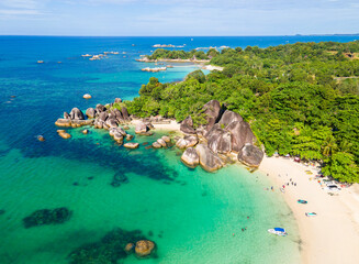 Stunning aerial view of Tanjung Tinggi Beach in Belitung, Indonesia. Known as 'Laskar Pelangi Beach', this popular destination features giant granite boulders and clear turquoise water.