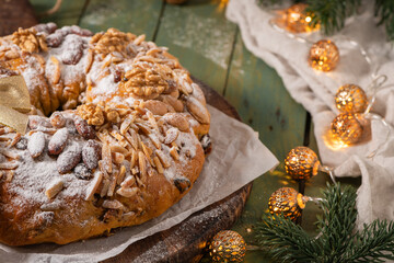 Bolo Rainha, a celebratory ring cake garnished with almonds, nuts, dried fruits, fruits raisins and dusted with powdered sugar, perfect for festive occasions like Christmas and New Year.