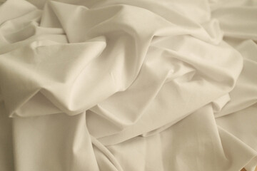 Obraz premium Closeup photo of a white knitted elastic fabric for sewing t-shirts or other clothes. Pleasant texture of high quality textile for clothes. Soft and cozy textile. Expensive fabric.