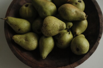 Organic farm green pears, autumn harvest. Not perfect uneven small pears organically grown without pesticides. Aesthetic artistic photo.
