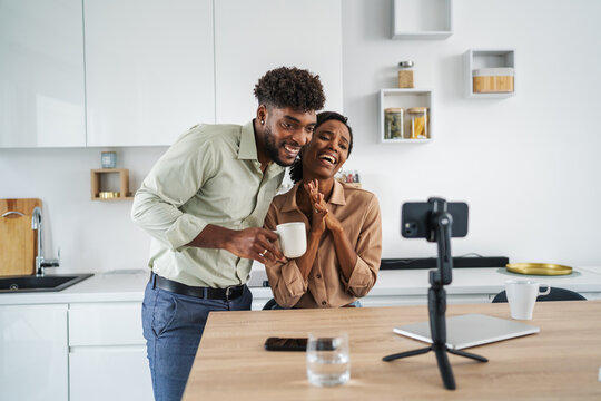 Happy couple enjoying video call in kitchen - Powered by Adobe