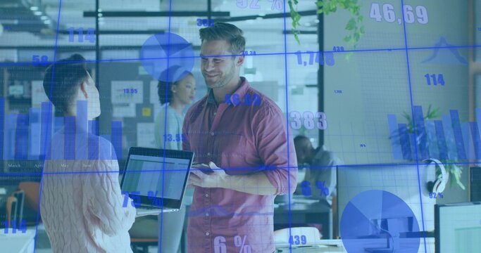 Talking man in mauve shirt with tablet, briefing coworker with laptop in open office, data overlay