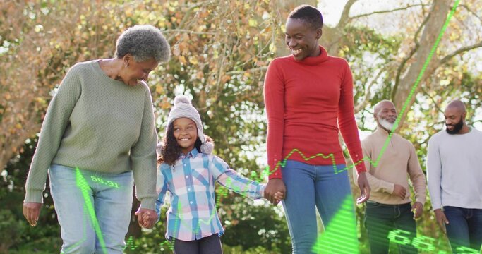 Walking African American family holding hands in park, wearing sweaters, pompom hat, green overlays