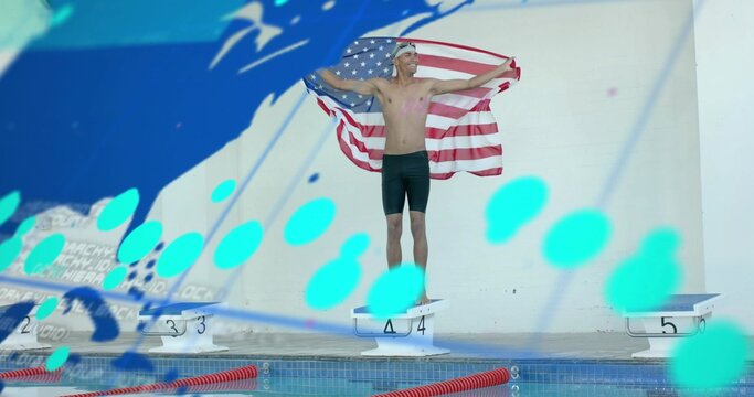 Standing male swimmer wearing white cap and dark jammers on starting block 4, holding American flag