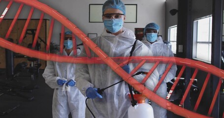 Holding spray tank, central woman wearing white suit preparing to spray in gym, DNA overlay