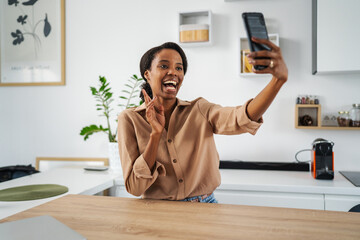 African american woman taking self portrait showing peace sign