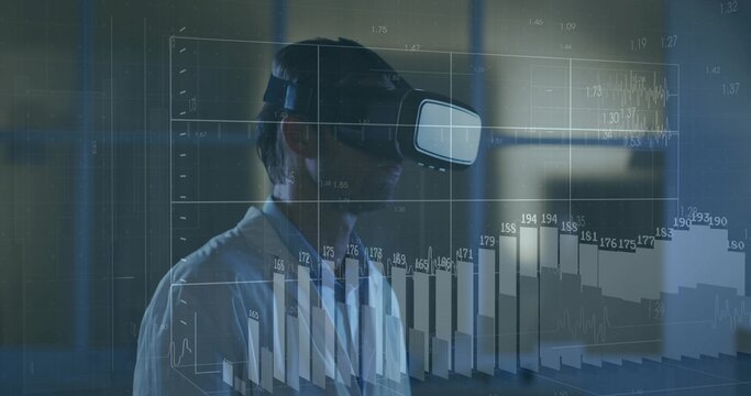 Exploring man in white collared shirt wearing VR headset manipulating holographic charts in dim lab