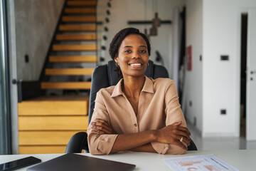 Professional african american woman working at home office desk smiling