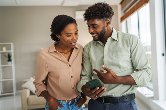 Black couple sharing device together at home